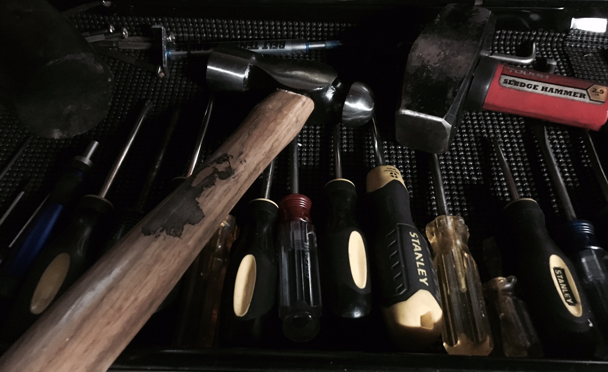 A picture of 3 hammers and multiple screwdrivers in a tool drawer