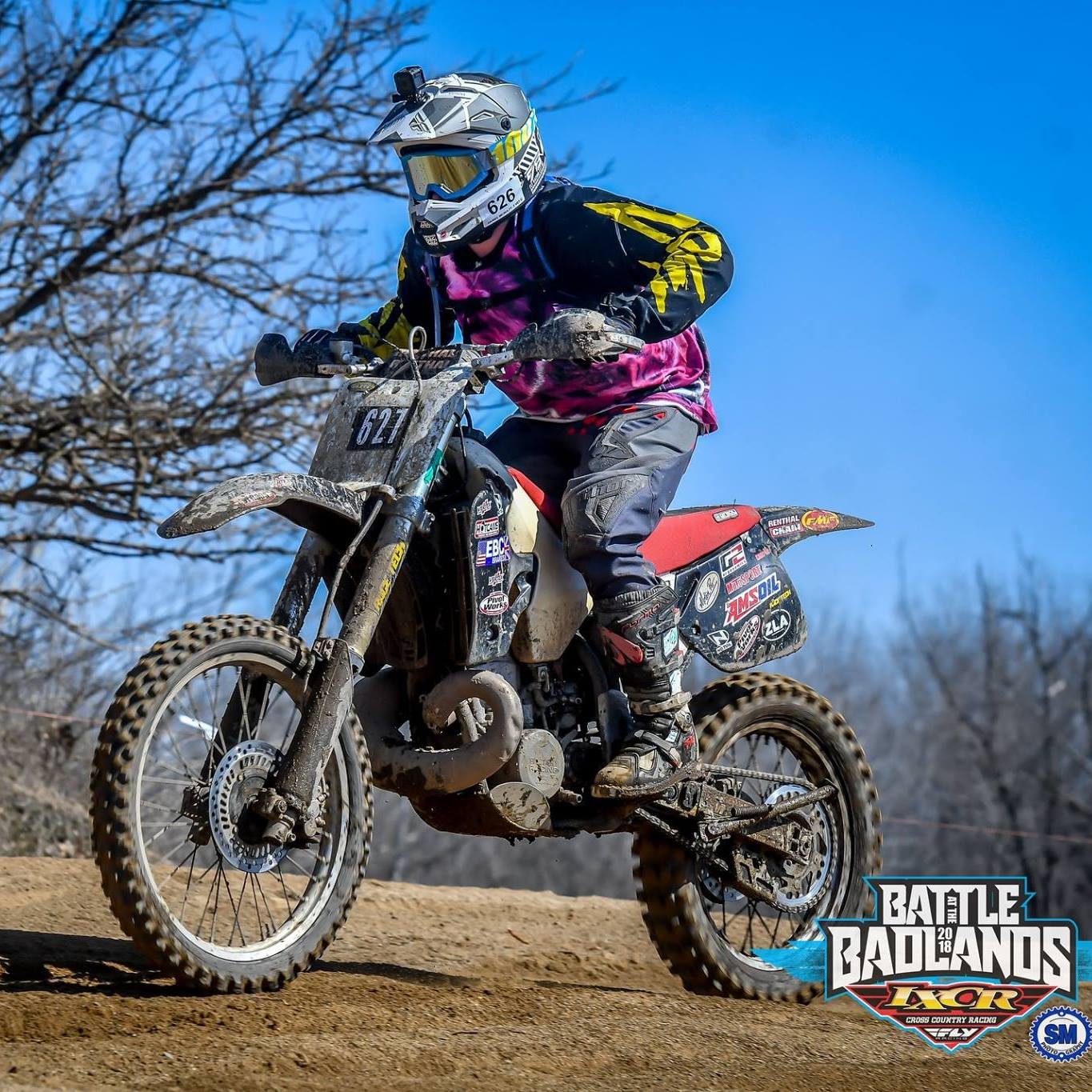 Daniel McNulty racing a dirtbike, standing on the foot pegs. 