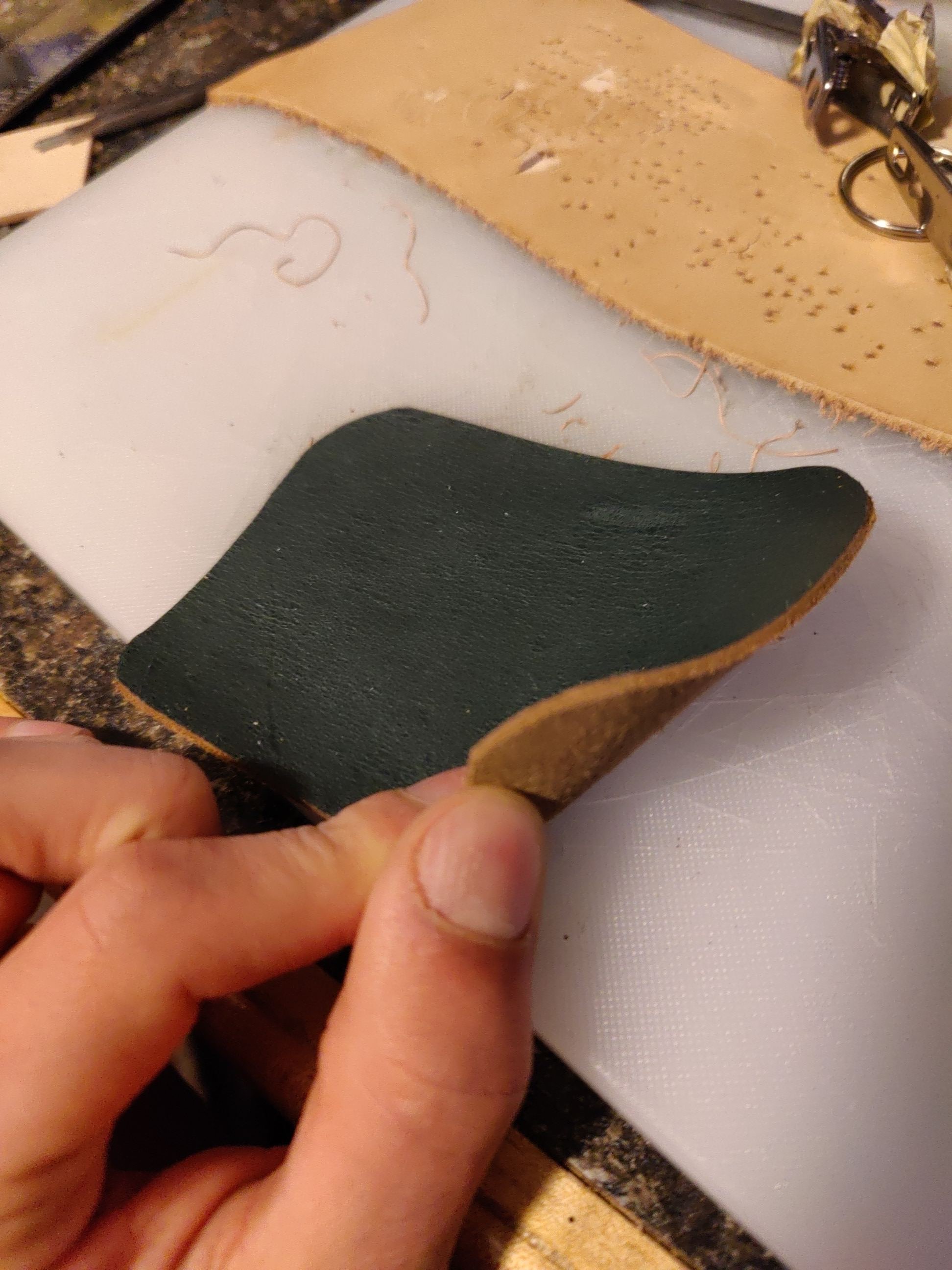 Photo of a hand hold up the corner of a piece of leather