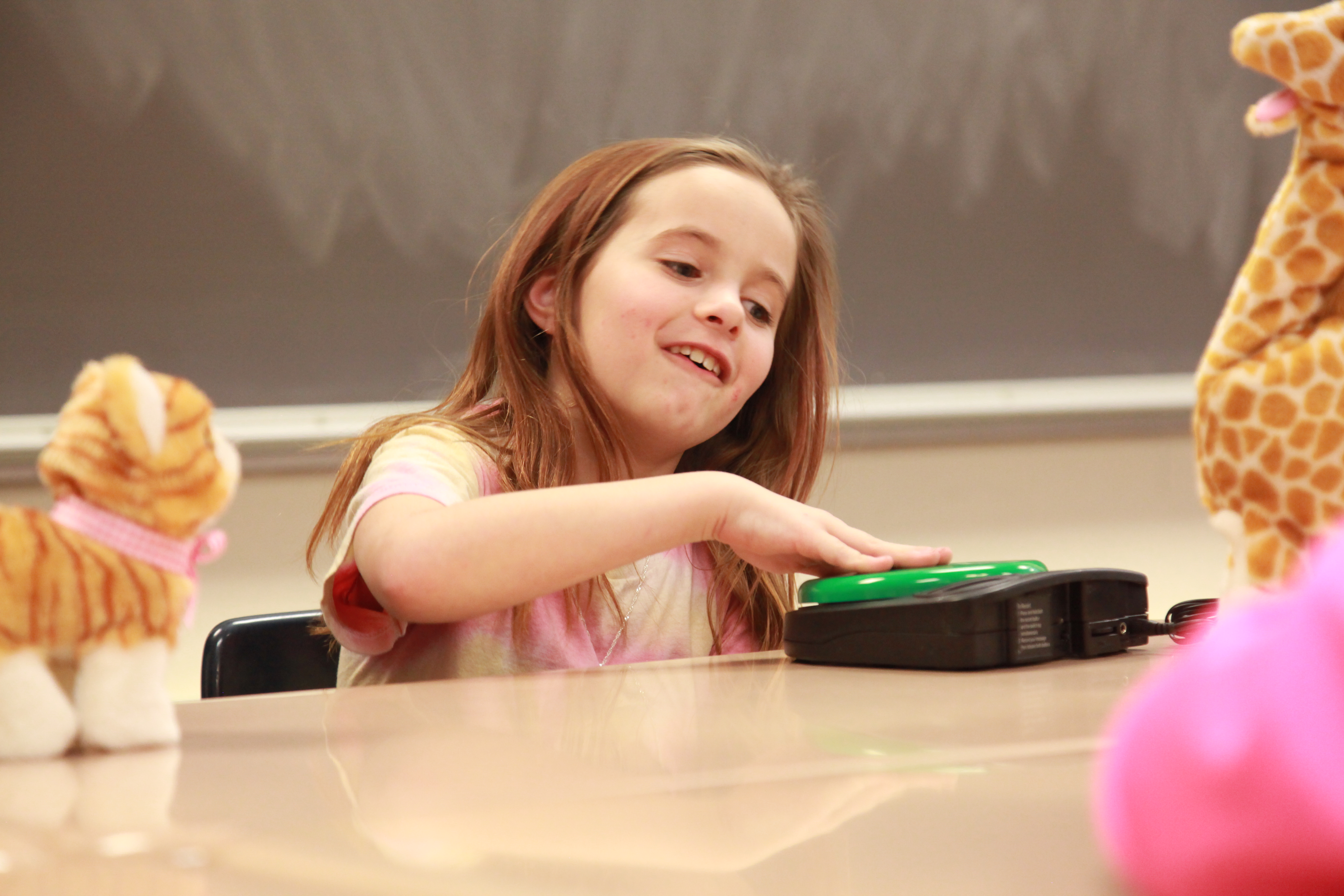 female student pressing a big switch to activate a toy