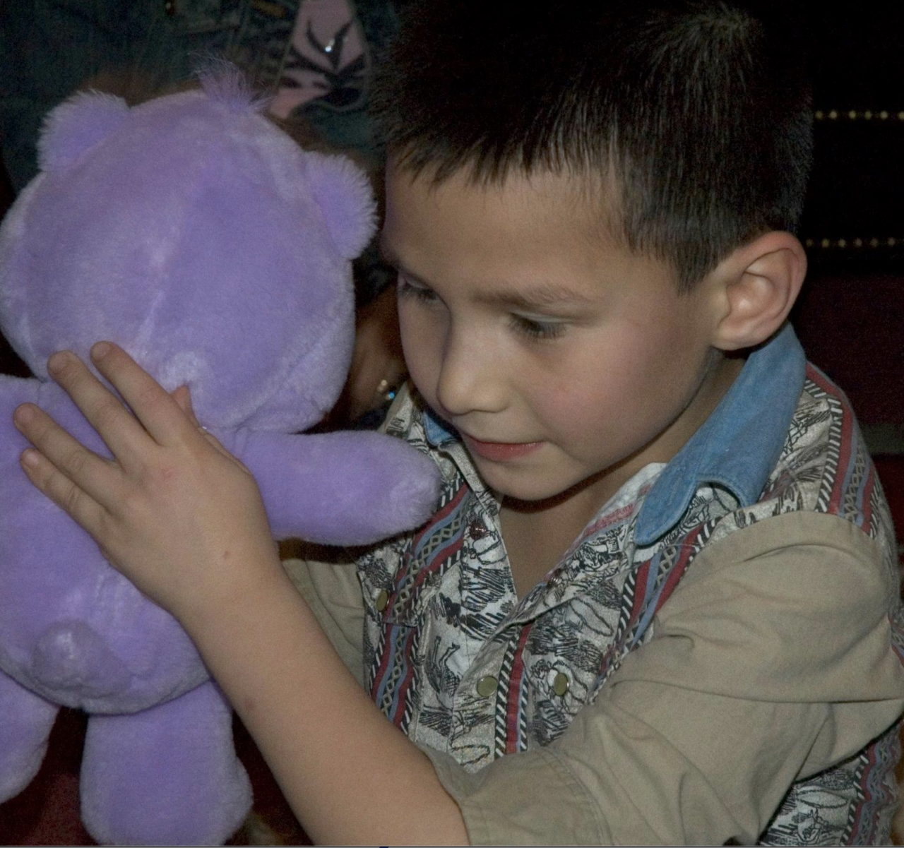 Young Derek holding a purple stuff bear