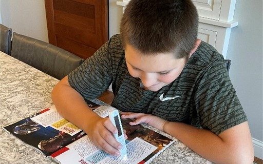 Student using C-Pen in magazine.