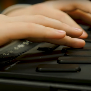 Close up of child's fingers using BrailleNote Touch.